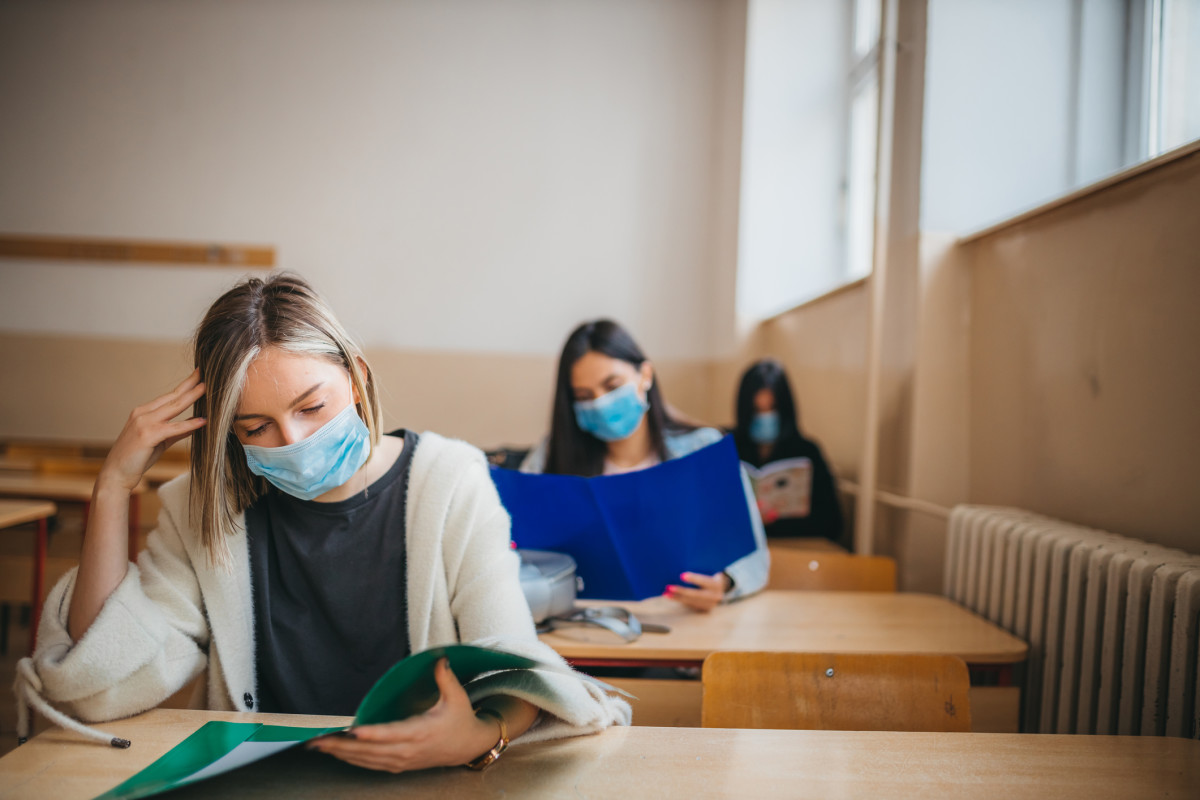 Students reading in a class while wearing a mask