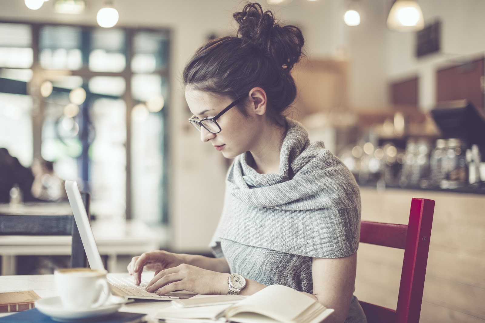 A teacher on a laptop, sitting in a cafe