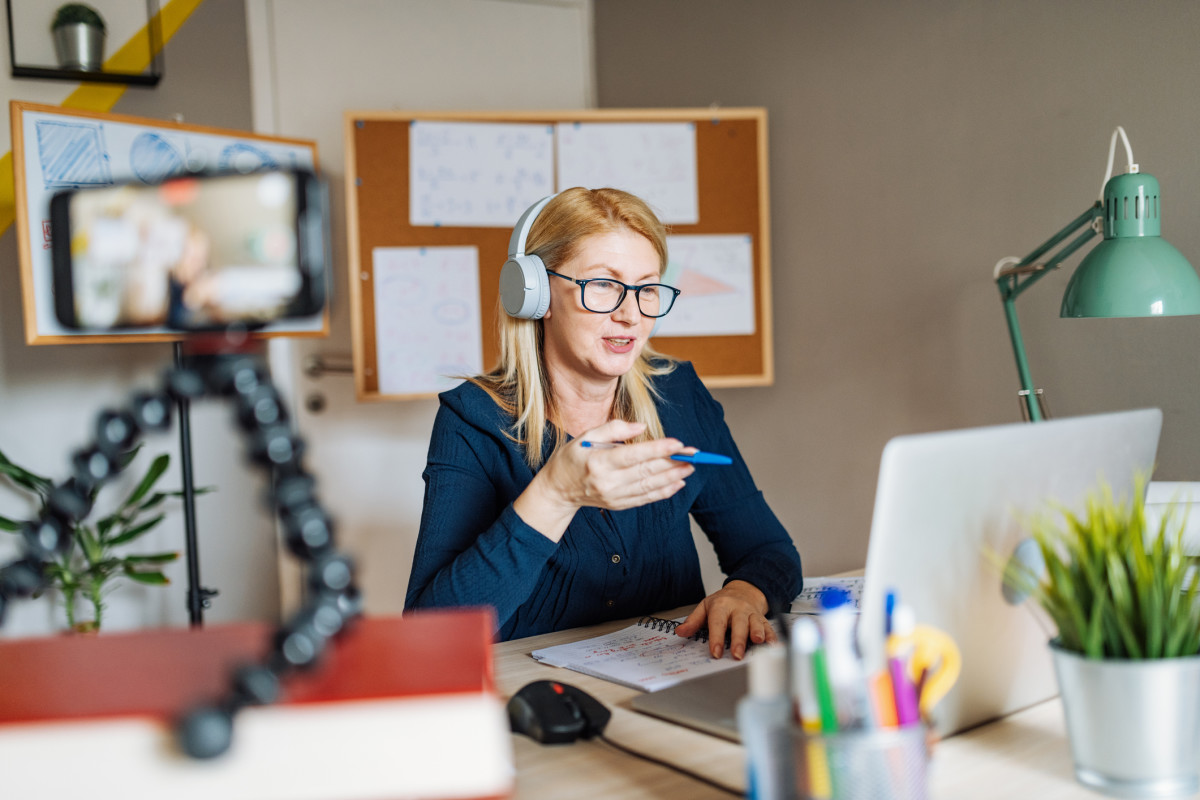 An image of a teacher sitting in a home office talking to a web cam