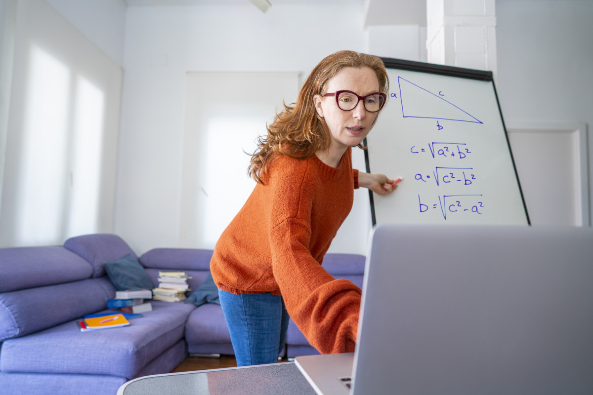 A woman virtually teaching math on a whiteboard