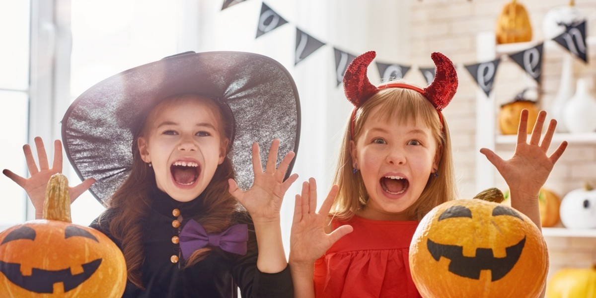 Two students in Halloween costumes, one a witch and another a devil