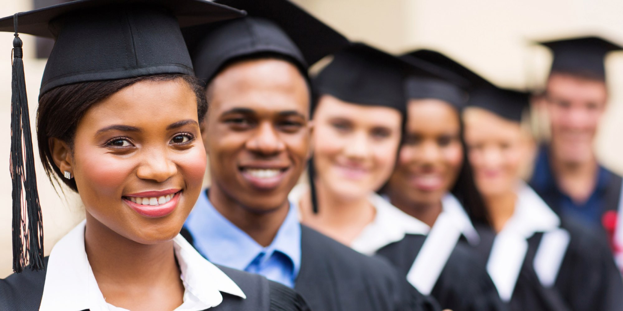 A diverse group of students in their graduation caps and gowns