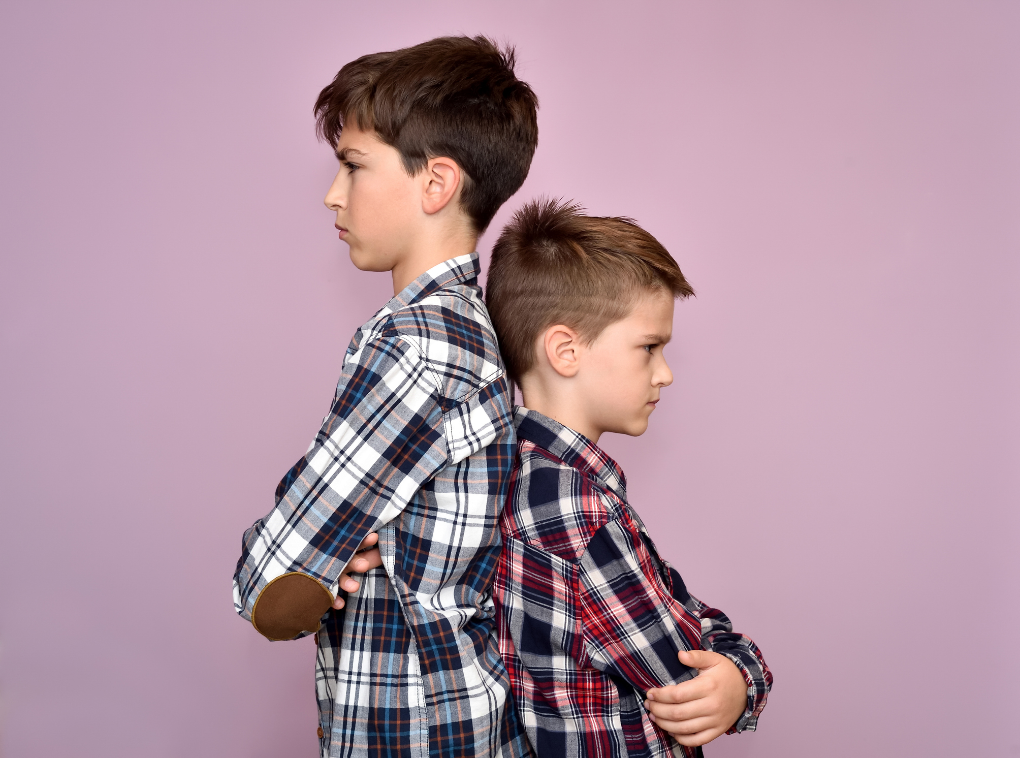 Photo of two boys with their backs turned and looking mad