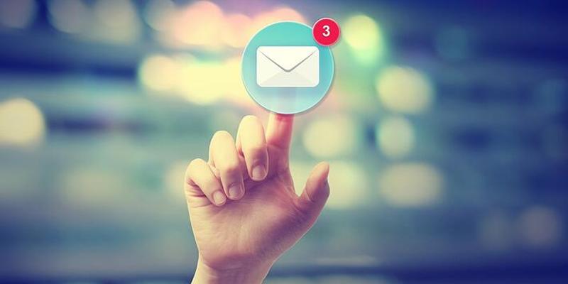 A person's finger clicking an email icon