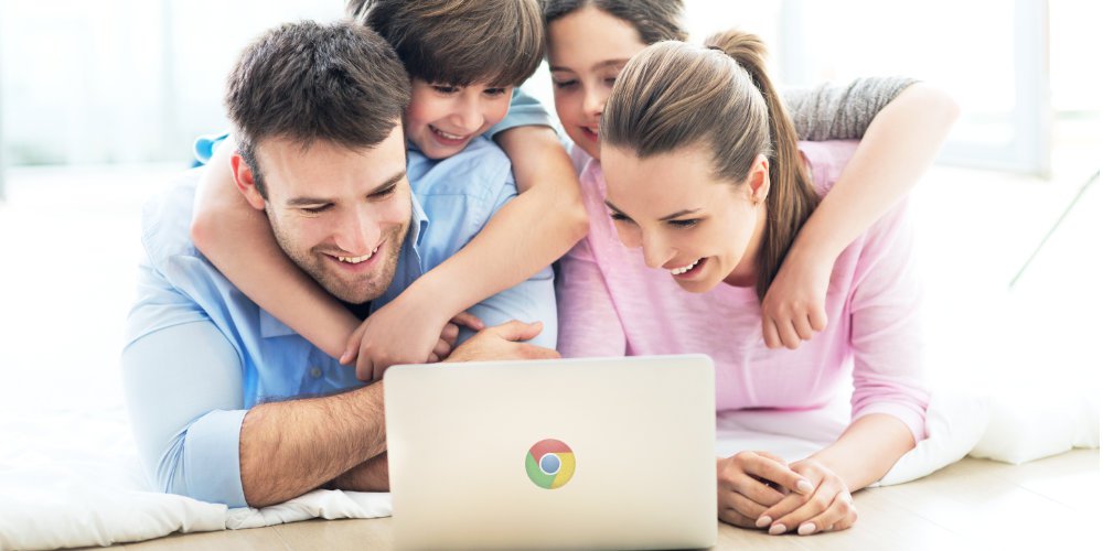 Family smiling at a laptop with a Google Chrome symbol on the lid