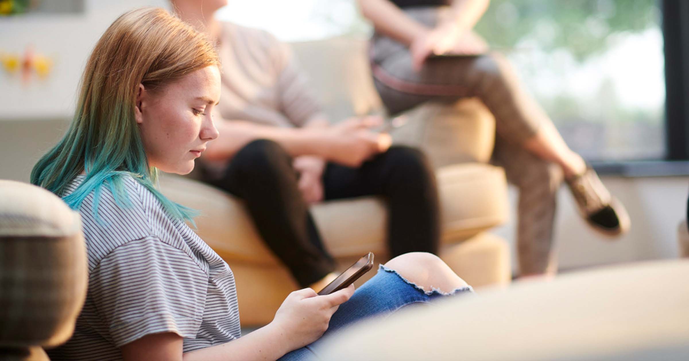 A girl looks at her cell phone screen